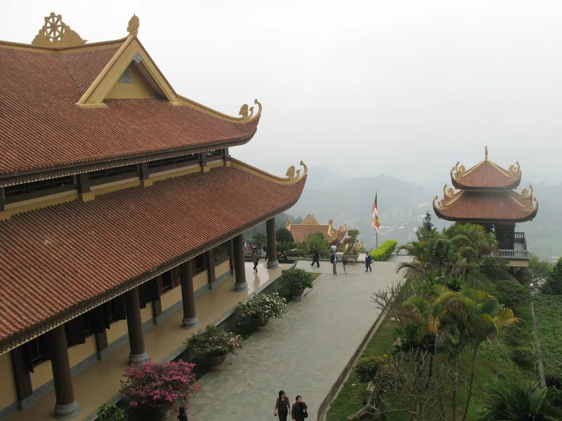 Các gian chính điện mái ngói đỏ của thiền viện Tây Thiên nhìn ra đồi núi sương mù gần Tam Đảo.